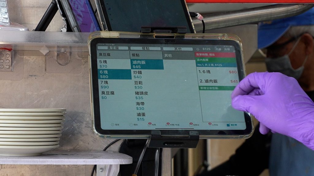 瑞穗臭豆腐店員使用微碧 POS 點餐系統，將介面調成大字版加寬菜單間距便於進行點餐作業